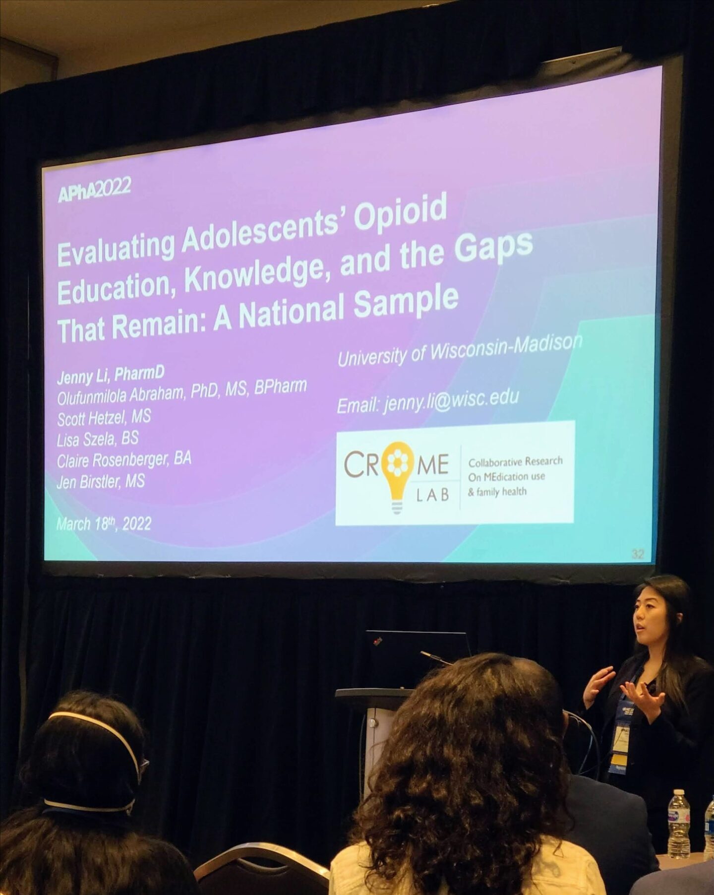 Jenny Li speaking in front of a large screen displaying the title "Evaluating Adolescents' Opioid Education, Knowledge and Gaps That Remain: National Sample"