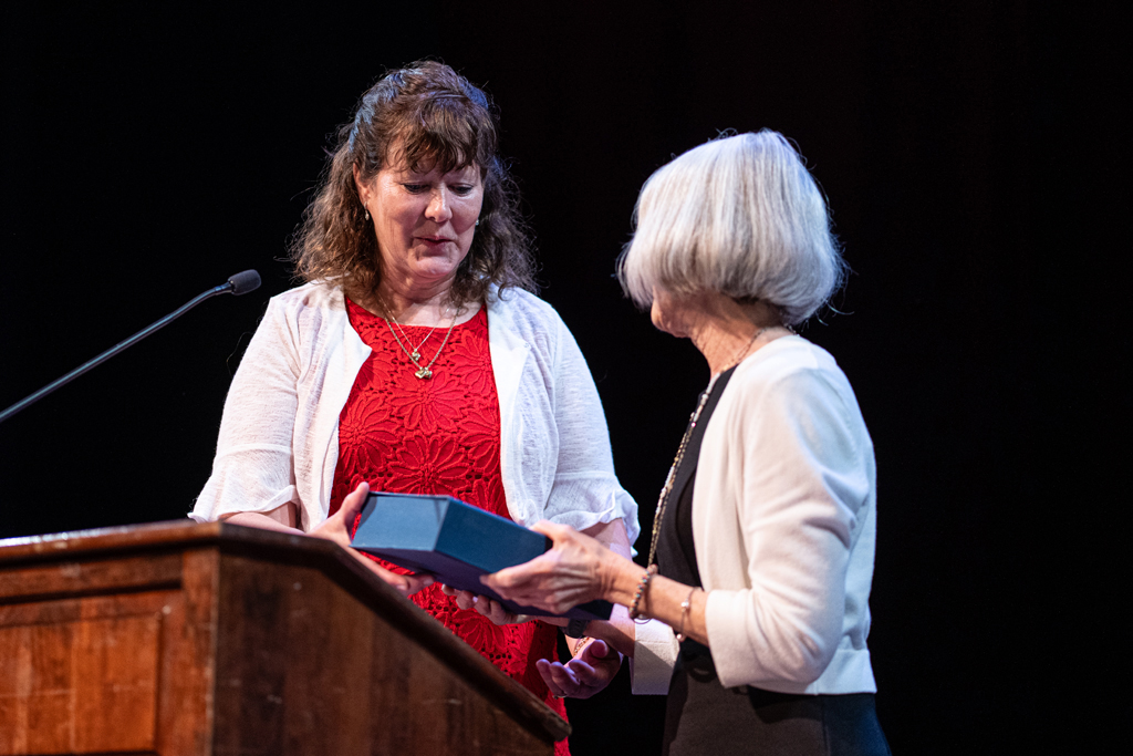 Jenny Moran receives an award from Mara Kieser behind a podium