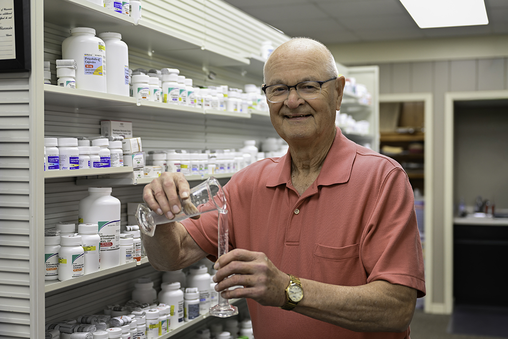 Jim Olson portrait in the pharmacy holding glassware