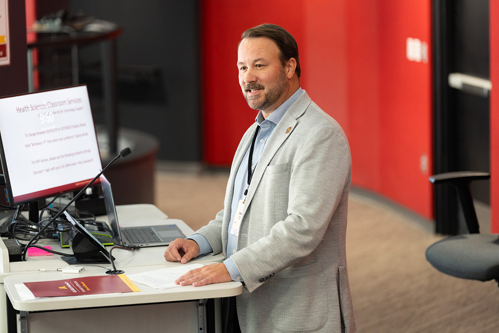 Joel Farley speaks in the front of a lecture hall