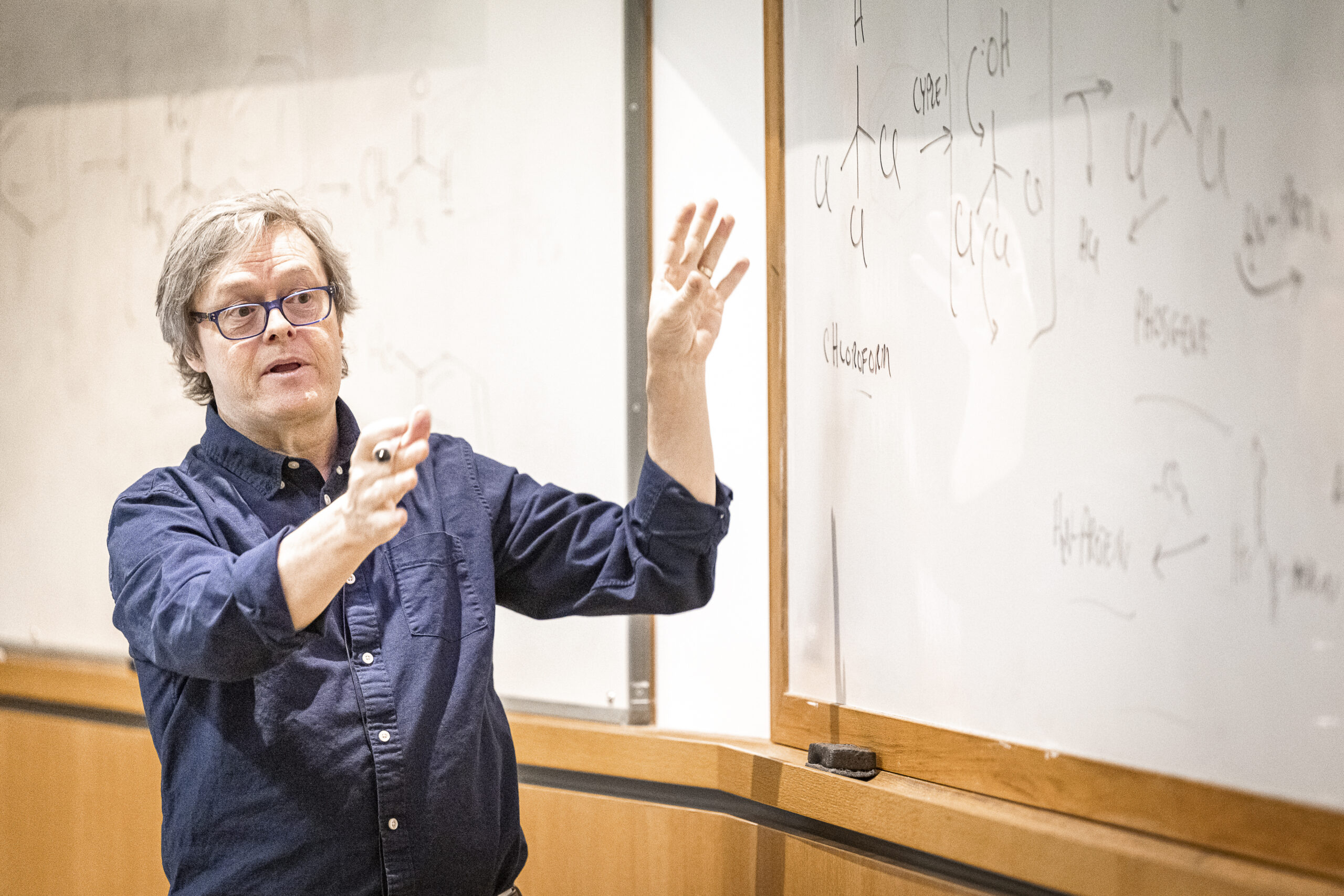 Charles Lauhon stands in front of a white board teaching a course. Photo by Bryce Richter