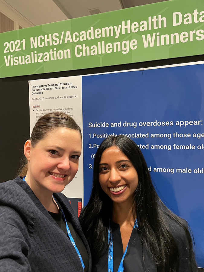 Laurel Legenza and Apoorva Reddy take a smiling photo at the 2021 NCHS/AcademyHealth Data Visualization Challenge Winners poster.