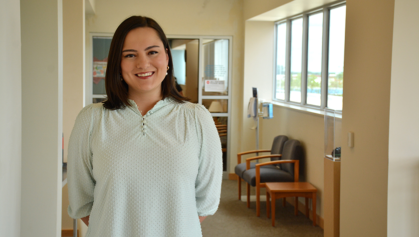 Maya Boguslawski stands in a waiting room and smiles