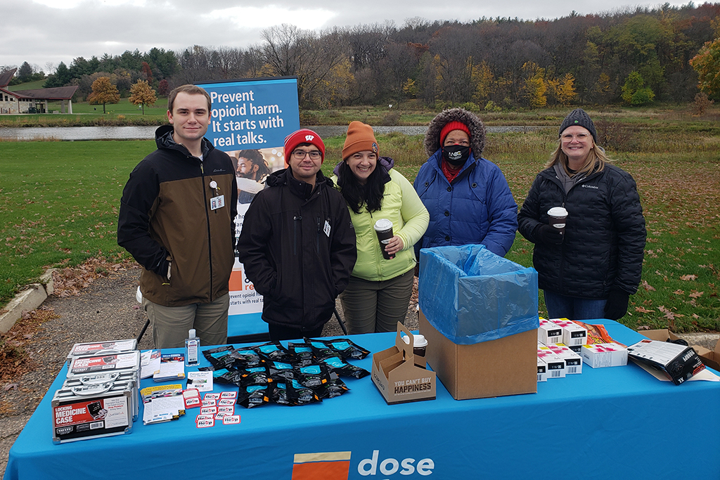 A group of PharmD students in winter coats outdoors at a drug takeback table. 