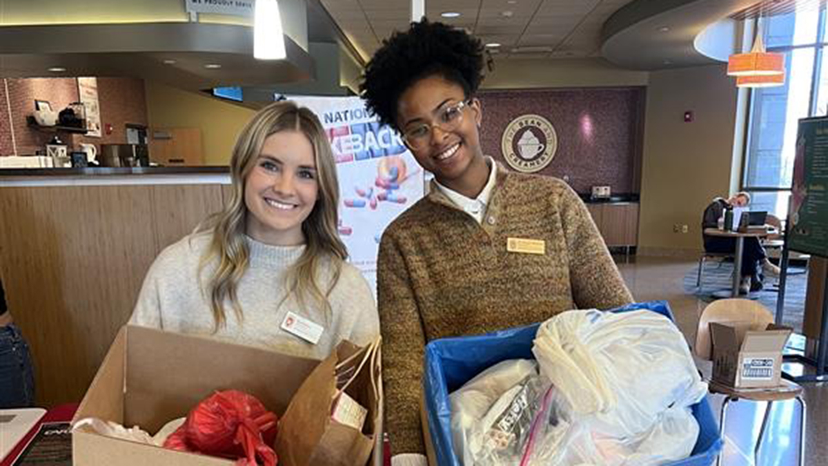 PharmD students holding two boxes of medications