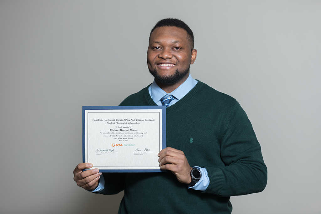 Michael Nome holding a certificate