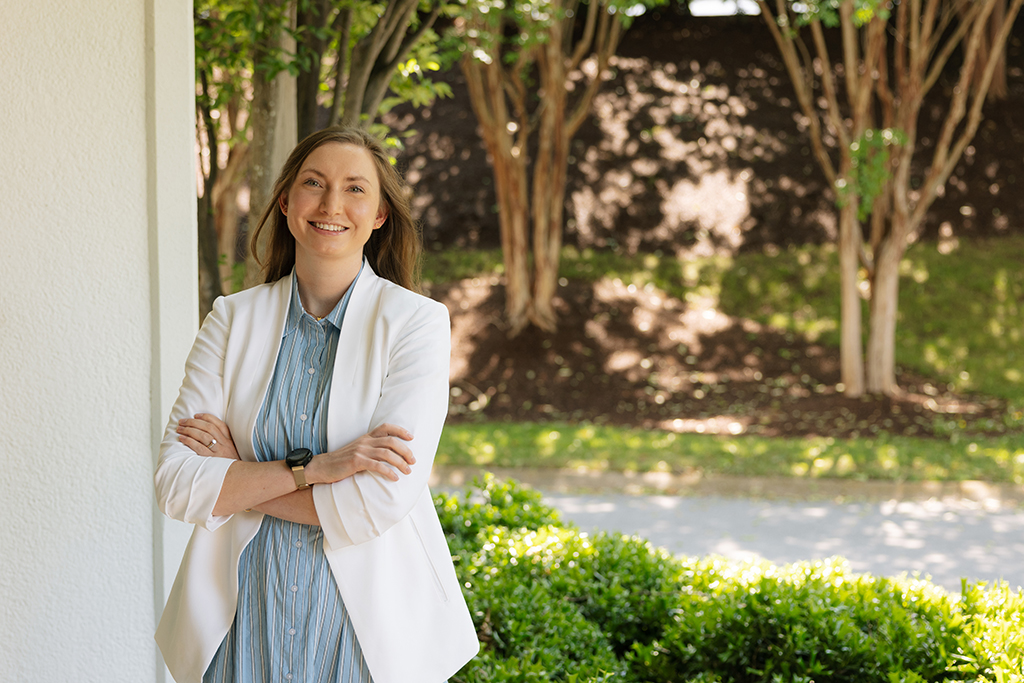 Miranda Murray poses outside near greenery