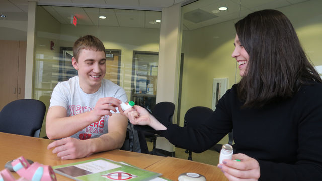 Elyse Keating giving Lucas Grabowski an inhaler