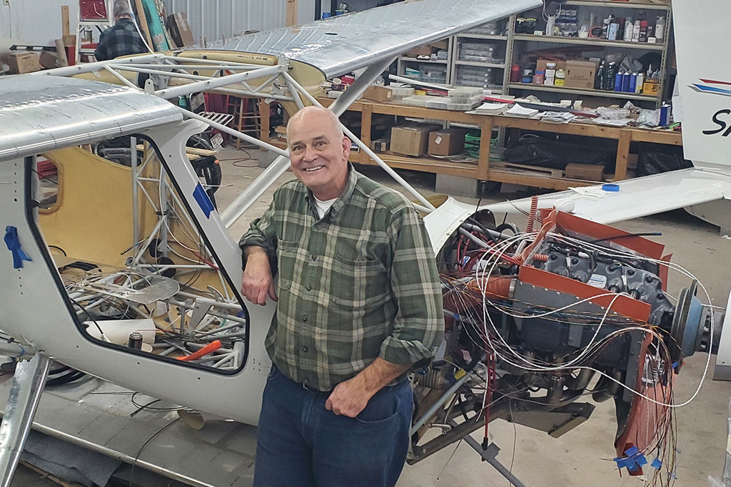 Paul Hutson poses with a half-built airplane