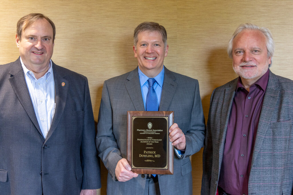 Pat Dowling poses with his Alum of the Year award, with Jeff Johnson and Dean Steve Swanson.