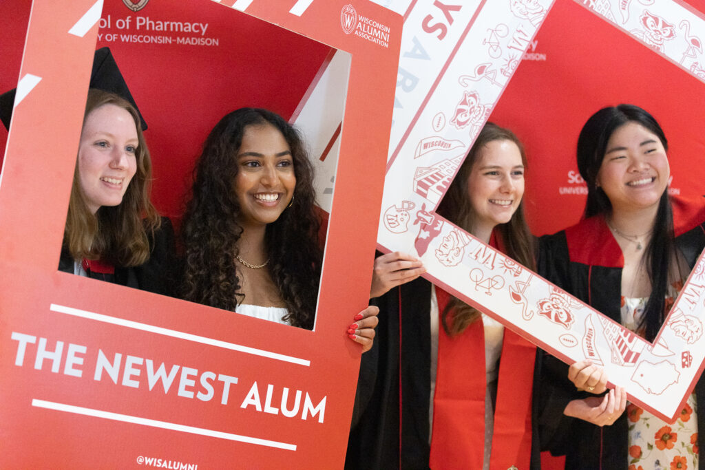 PharmTox graduates pose in "newest alum" photo frames.