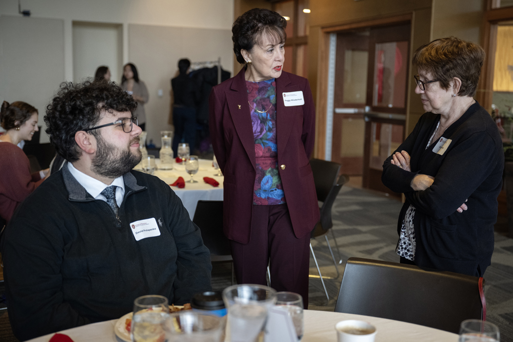 PharmD students speak with donors at a table.