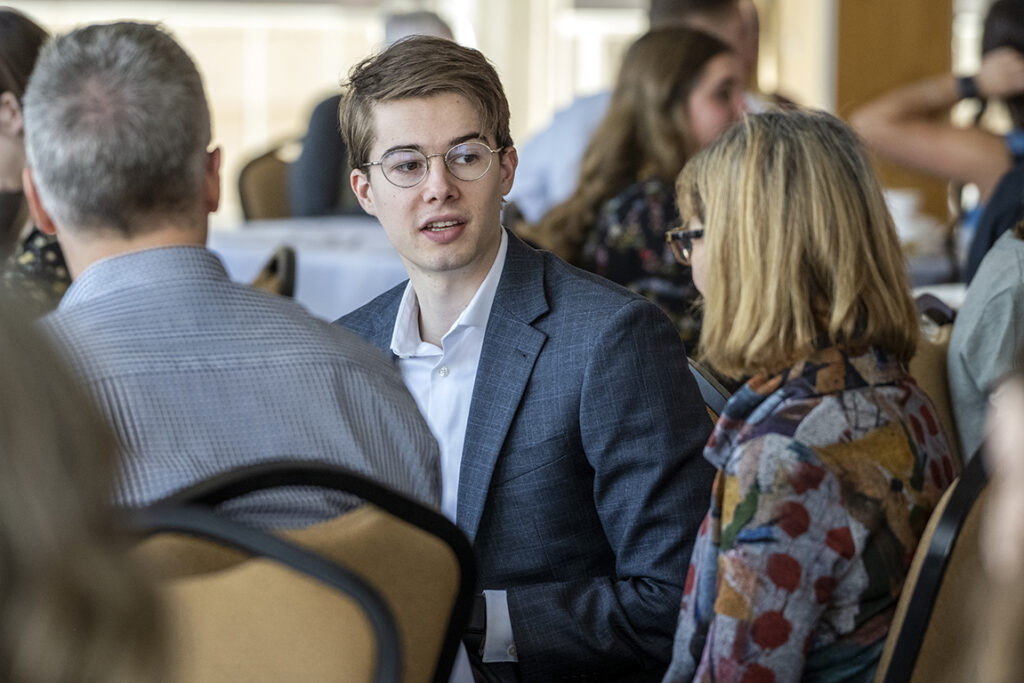 Fourth-year PharmD student Alex Peterson talks with his mother, Debbi Peterson, as his father looks on during the 2022 School of Pharmacy Scholarship Brunch