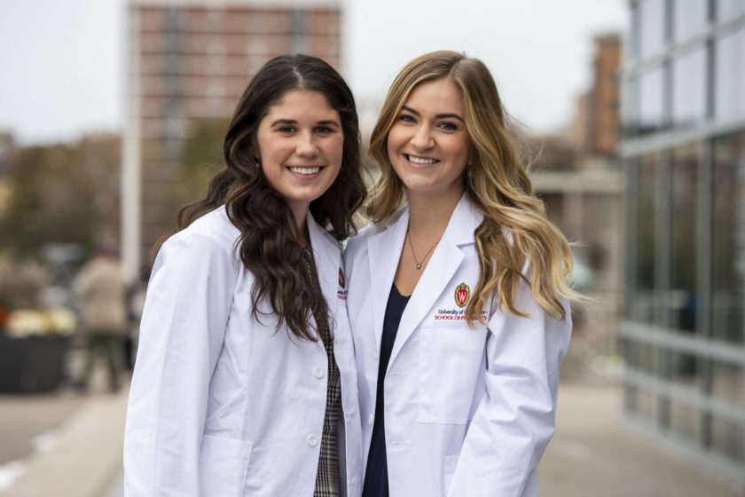Two students in white coats together after white coat ceremony