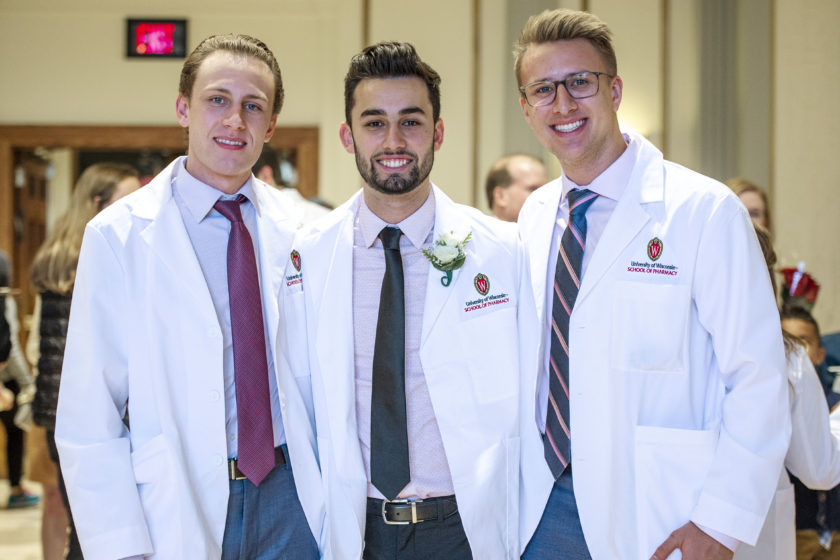 Three students in white coats together after white coat ceremony