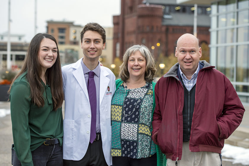Student in white coat with their family after white coat ceremony