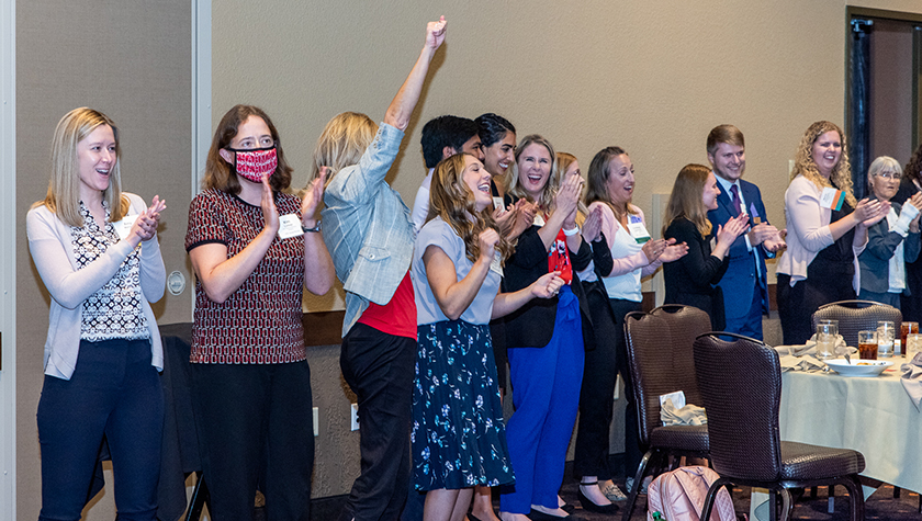 A group of alumni celebrate in a line