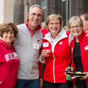 A SoP alumni family poses together at a tailgating party
