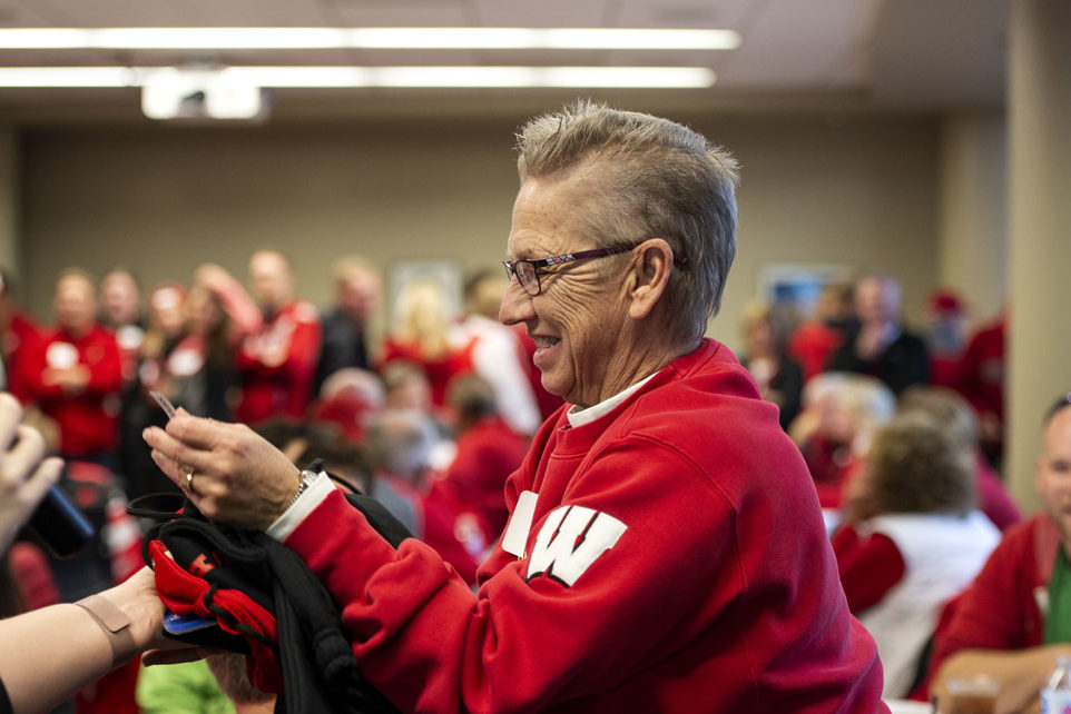 An alumna celebrating a raffle win at the UW-Madison Pharmacy Alumni Tailgate event, held at Union South during the Badgers vs. Cornhuskers game.