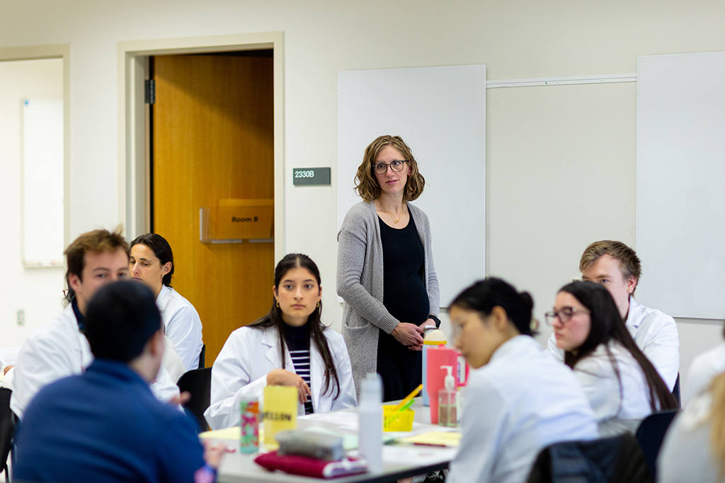 Jessica Bergsbaken stands and oversees student activity in a classroom