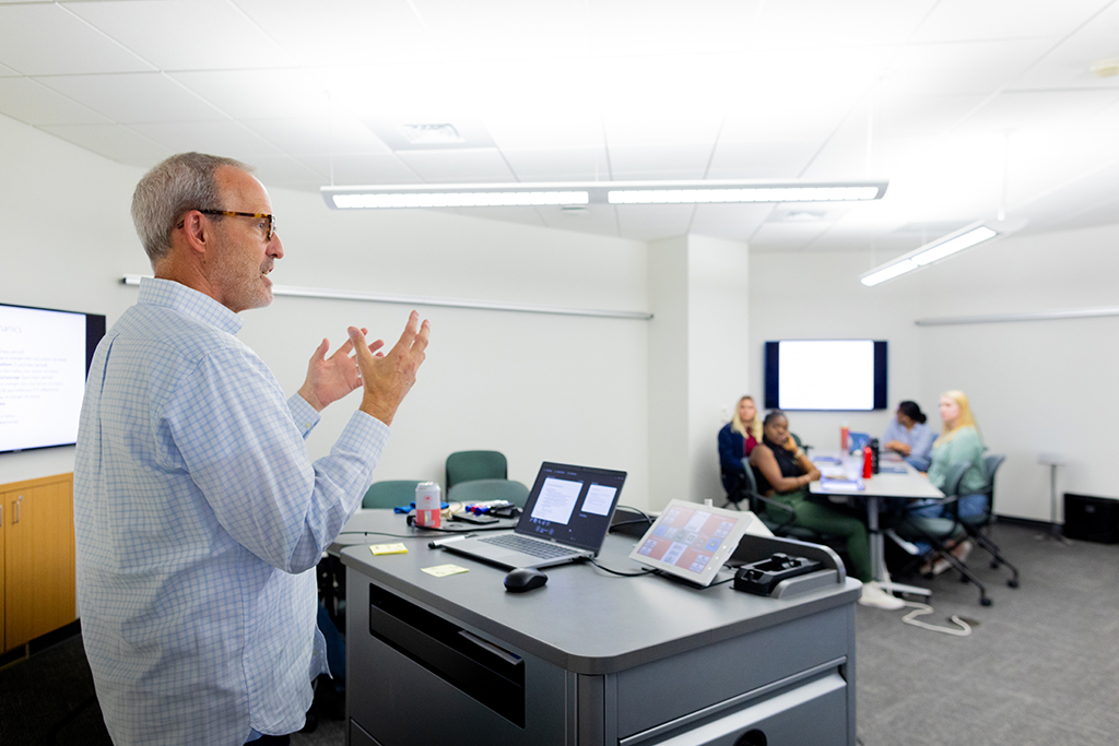 Dave Mott speaks in front of a class