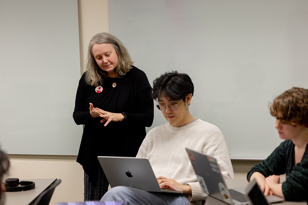 Lara Collier looks over the shoulder of a student during the Grant Writing course