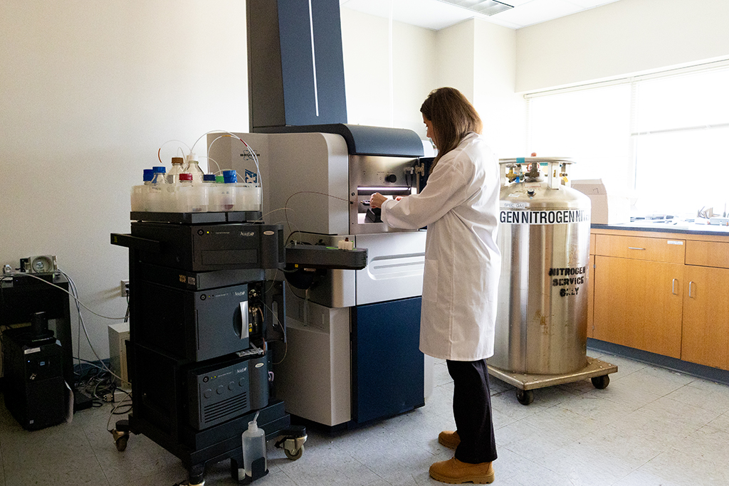 Molly Pellitterli Hahn works on a large mass spectrometry machine