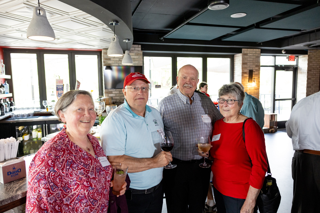 Jim Demuth, Pam Ploetz and two other alumni smile for a photo