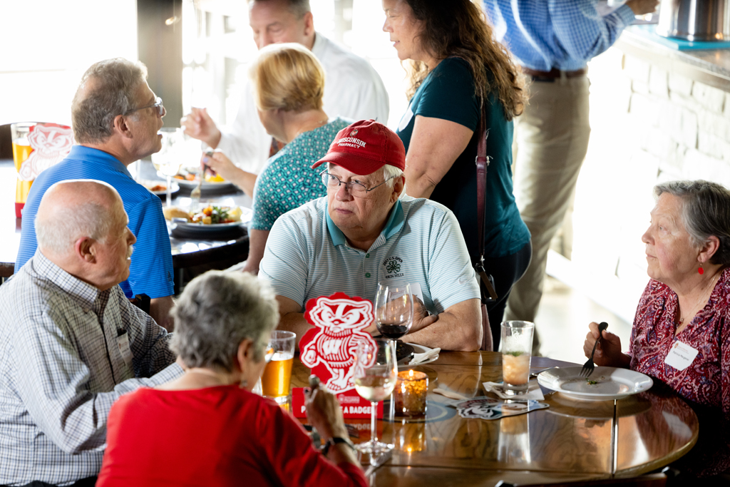 A group of alumni speak over dinner