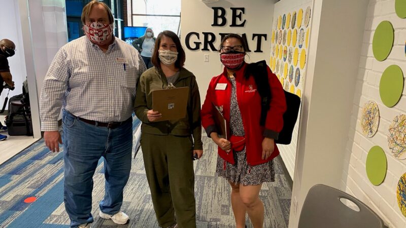 Steve Swanson with Lisa Imhoff and Alyson Kim wearing masks and holding clipboards in Sun Prairie vaccination clinic