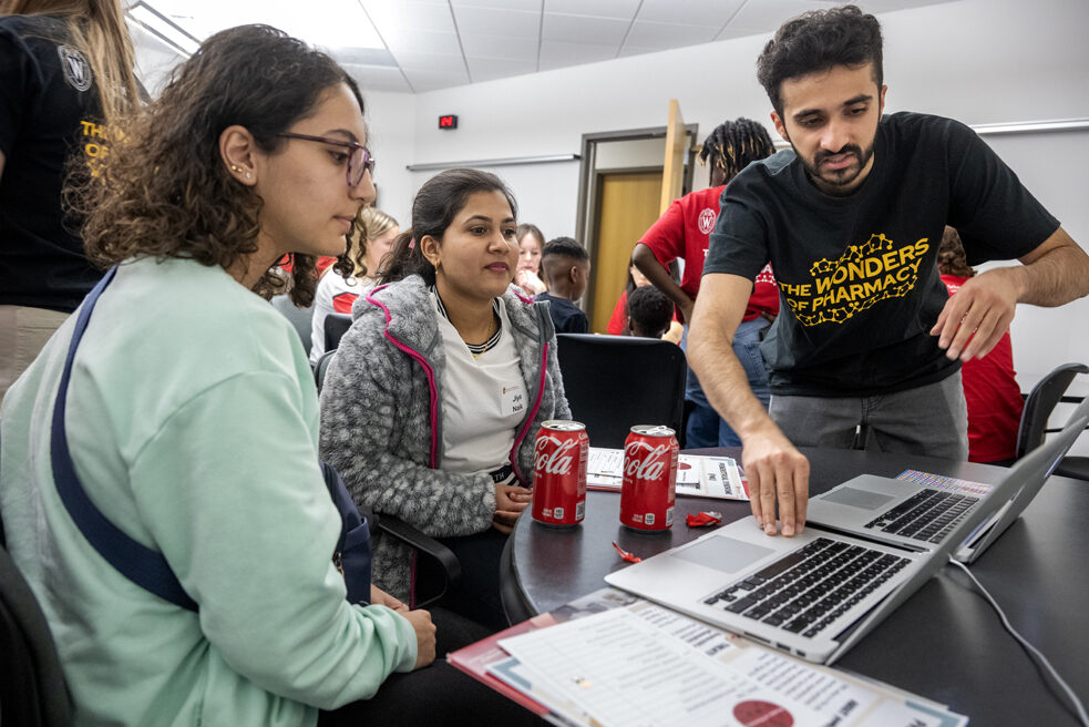Third-year PharmD student Talha Mohammad chats with (l to r) Jana Alhuniti and Jiya Naik about the MEDSMART: Adventures in PharmaCity game during the Wonders of Pharmacy on Saturday, March 2, 2024, at the School of Pharmacy on the campus of UW-Madison. (Photo Paul L. Newby, II)
