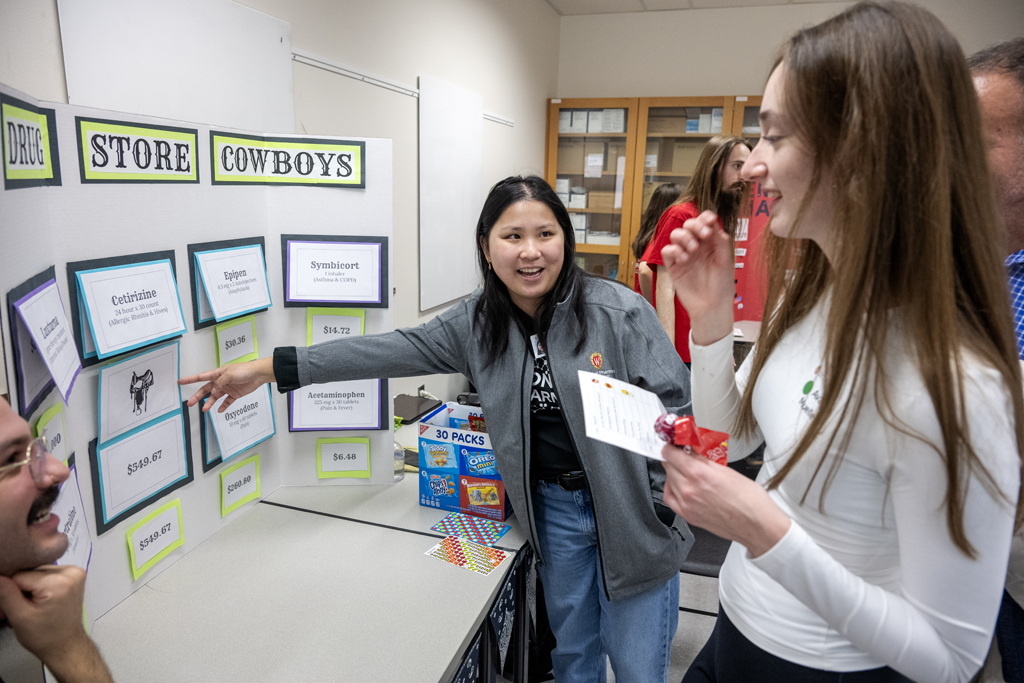 First-year PharmD student Emily Lloyd reveals the correct answers after Ava Mueller tried her luck at The Drug Store Cowboys game during the Wonders of Pharmacy on Saturday, March 2, 2024, at the School of Pharmacy on the campus of UW-Madison. (Photo Paul L. Newby, II)