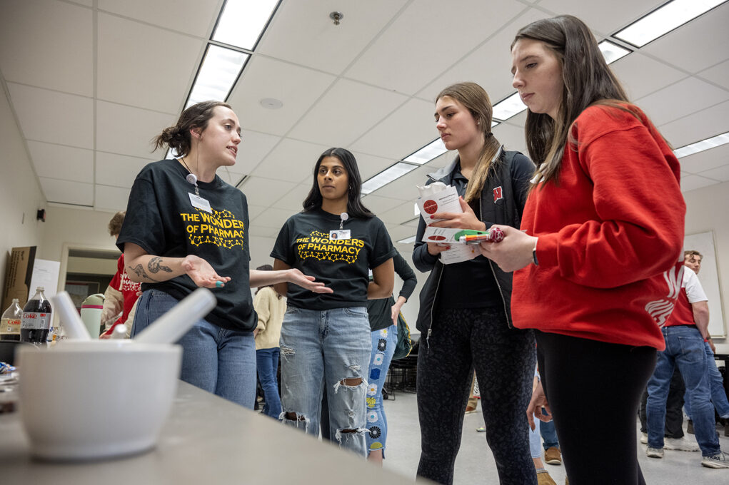 First-year PharmD student Sydney Van Otterloo explains the object of the Rx-ceptional Compounding activity to Rylee Betthauseer and Lily Dunsirn during the Wonders of Pharmacy on Saturday, March 2, 2024, at the School of Pharmacy on the campus of UW-Madison. (Photo Paul L. Newby, II)