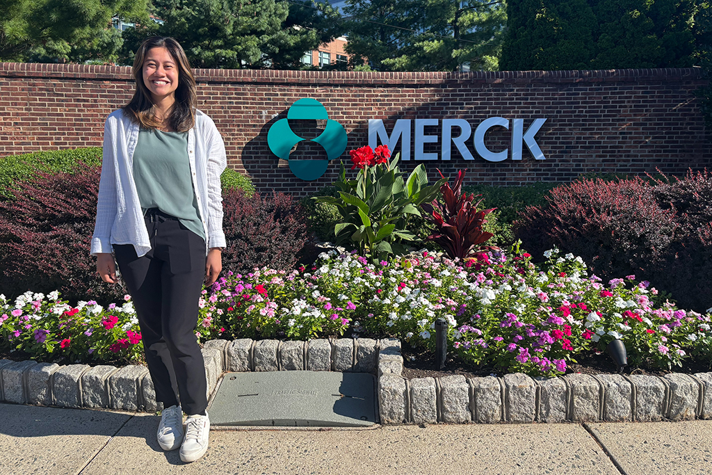 Tina Dang stands near the Merck sign outdoors
