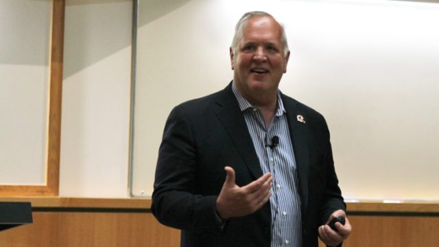 Tom McCourt speaking at front of lecture hall