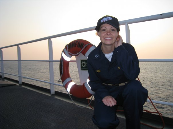 Sara Camilli on a boat in a Naval uniform during sunset.