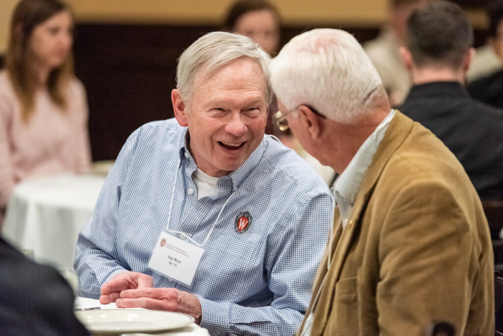 Alumni laughing together at a table