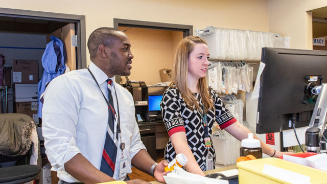 Hussain Harun and Abigail Moore working at station in pharmacy