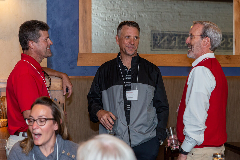 Dave Mott speaking with other staff and alumni at Cooper's Tavern