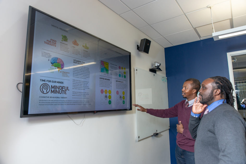 Kwadwo Owusu-Ofori and Walter Matthews looking at infographic detailing purpose behind their product