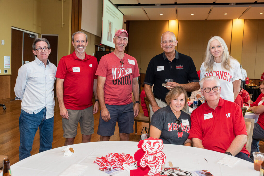 A group of alumni, including John Swann, Rick Bertz, and others, smile at the camera with Professor Paul Hutson and Associate Dean for Advancement Dave Mott.
