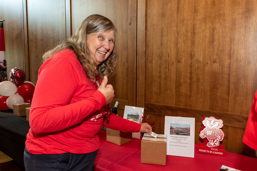 An alumna gives a thumbs up as she bids on a raffle item.