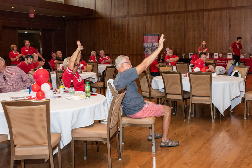 Alumni raise their hands as they win a raffle item.