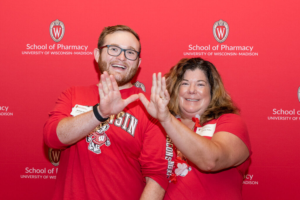 Nicholas and Terry Adler pose with their hands held in a "W"