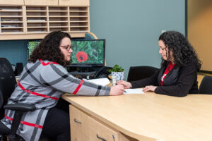 Michelle Violi, Gina Besteman working at a desk.