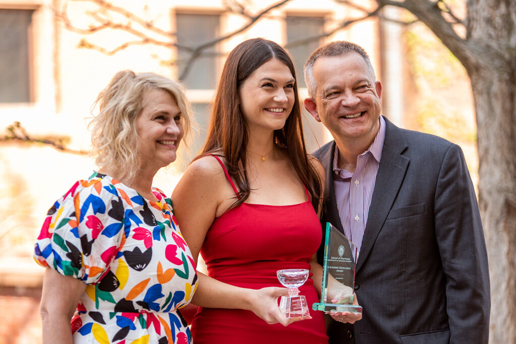 UW Pharm Award recipient holding her awards with her parents