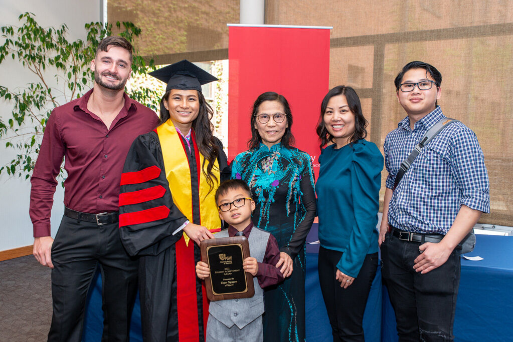 UW Pharm award recipient in her gown, surrounded by family