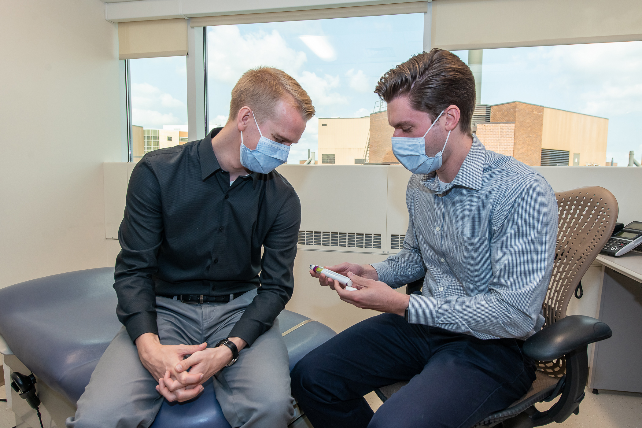 Tyler Albright and Ryan Simonet discussing an item in an office at the VA