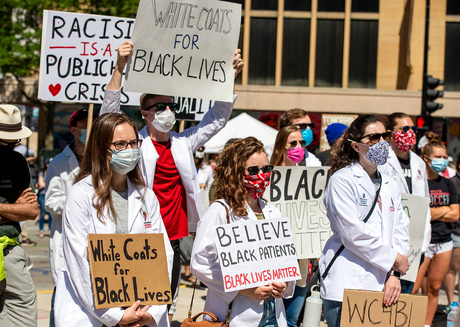 Students holding signs during white coats for black lives march