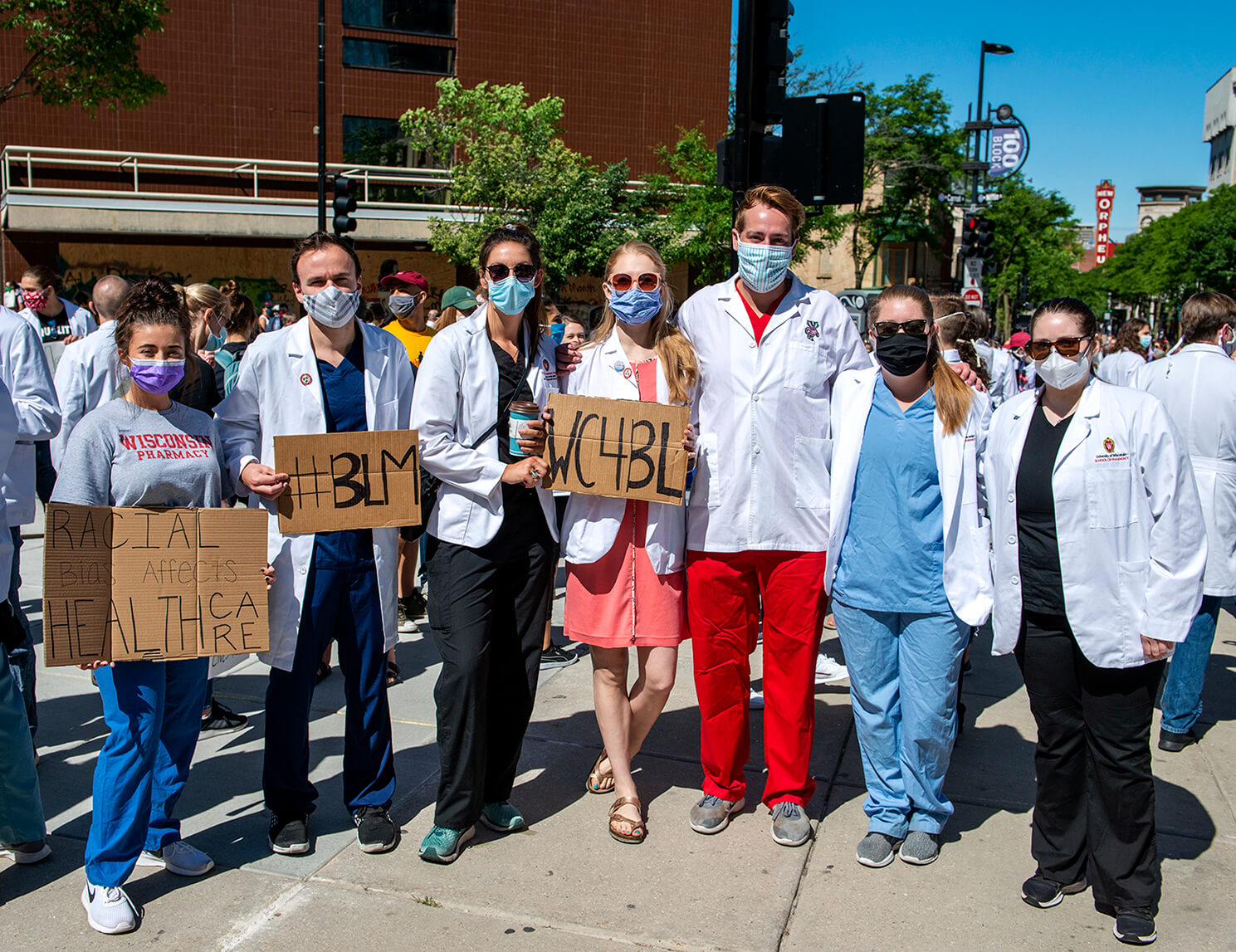 PharmD students holding in scrubs during white coats for black lives march